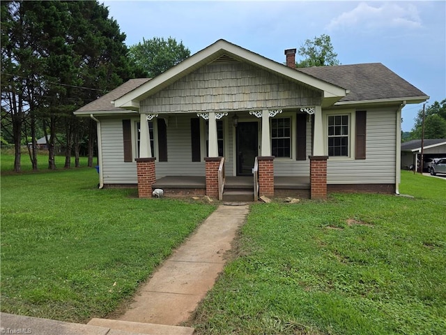 117 Hillcrest St, Jonesville, NC 28642 - bungalow-style house featuring covered porch, a front lawn, a chimney, and a shingled roof