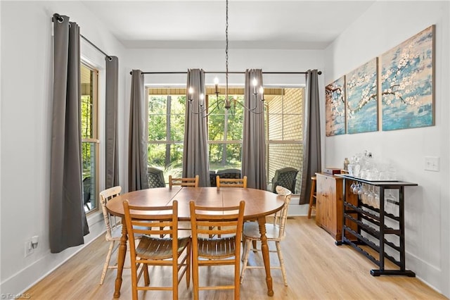 dining area with an inviting chandelier and light hardwood / wood-style flooring