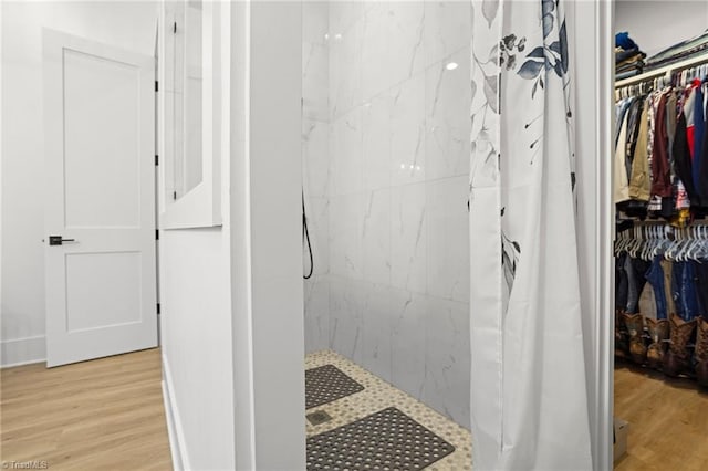 bathroom featuring hardwood / wood-style flooring and walk in shower