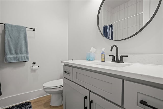 bathroom featuring walk in shower, vanity, toilet, and wood-type flooring