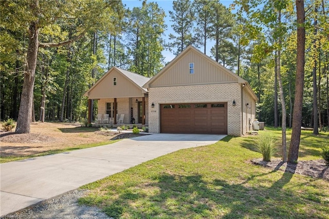 view of front of house featuring a porch, a garage, and a front lawn