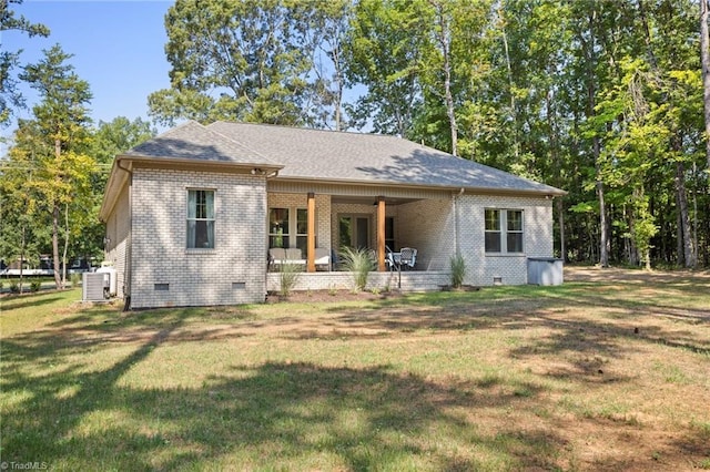 view of front of home featuring cooling unit and a front yard