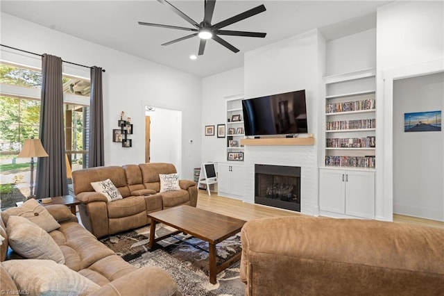 living room with hardwood / wood-style flooring, ceiling fan, and built in features