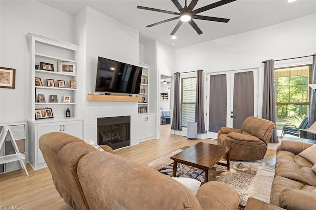 living room featuring ceiling fan, light hardwood / wood-style floors, and built in features