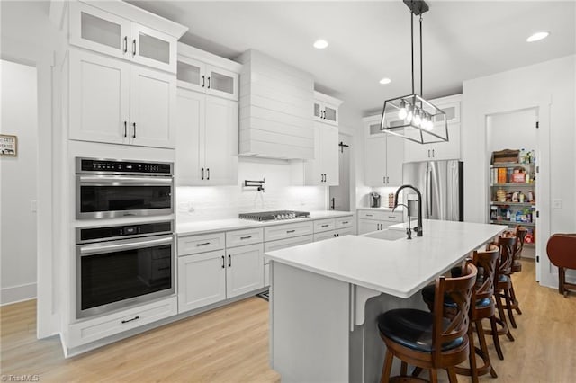 kitchen with white cabinetry, an island with sink, appliances with stainless steel finishes, and sink