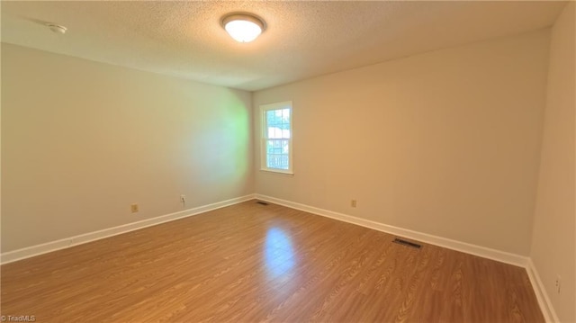 3128 Burke Mill Ct, Winston-Salem, NC 27103 - empty room featuring a textured ceiling, wood finished floors, and a smoke detector