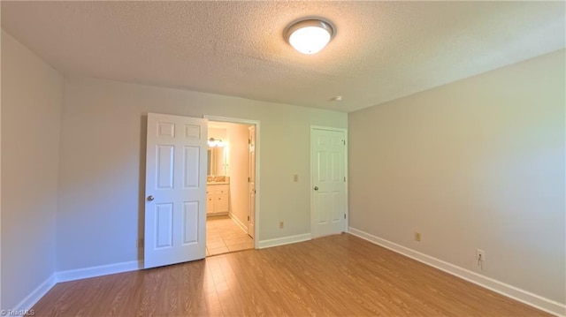 3128 Burke Mill Ct, Winston-Salem, NC 27103 - unfurnished bedroom with a textured ceiling, light wood-type flooring, and connected bathroom