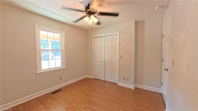 3128 Burke Mill Ct, Winston-Salem, NC 27103 - unfurnished bedroom featuring light wood-style floors, a closet, a textured ceiling, and ceiling fan