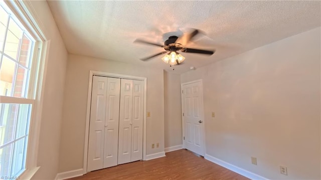 3128 Burke Mill Ct, Winston-Salem, NC 27103 - unfurnished bedroom with wood finished floors, a textured ceiling, a closet, and ceiling fan