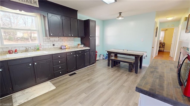 kitchen with sink, backsplash, and light hardwood / wood-style floors