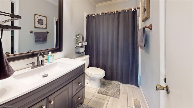 bathroom featuring vanity, ornamental molding, toilet, and walk in shower