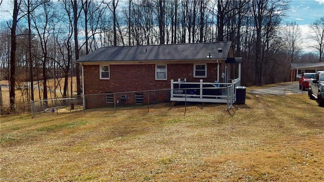 rear view of house with a wooden deck and a lawn