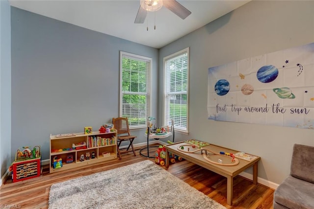 game room with baseboards, wood finished floors, and ceiling fan