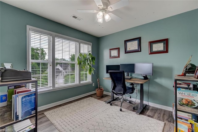 office featuring baseboards, a ceiling fan, and wood finished floors