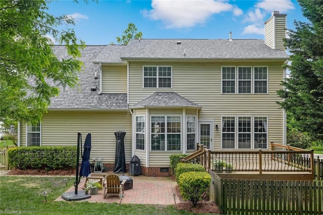 back of property featuring a deck, a patio area, a shingled roof, crawl space, and a yard