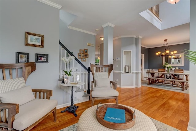 living area with wood finished floors, ornamental molding, stairway, a chandelier, and baseboards