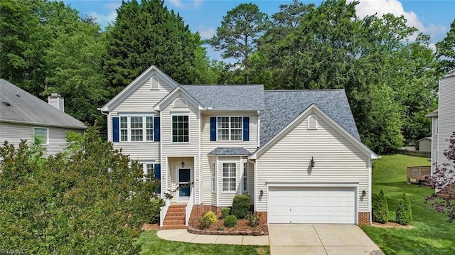 view of front facade with a front yard, driveway, and roof with shingles