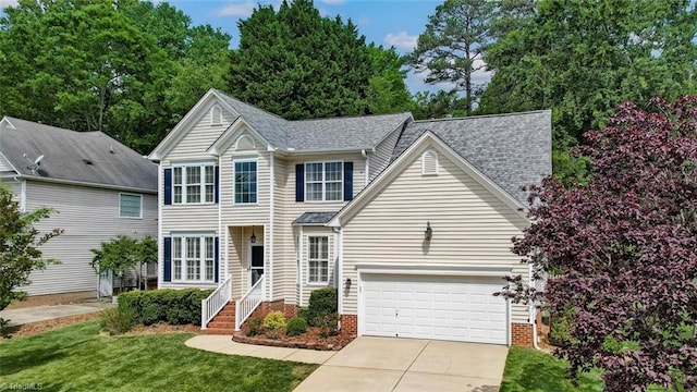 view of front of house with driveway, a front lawn, and a shingled roof
