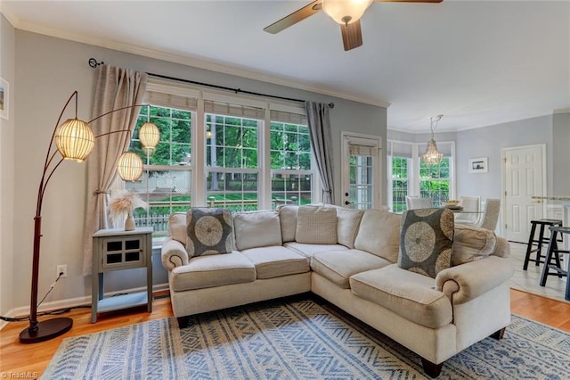 living room with a ceiling fan, ornamental molding, wood finished floors, and baseboards