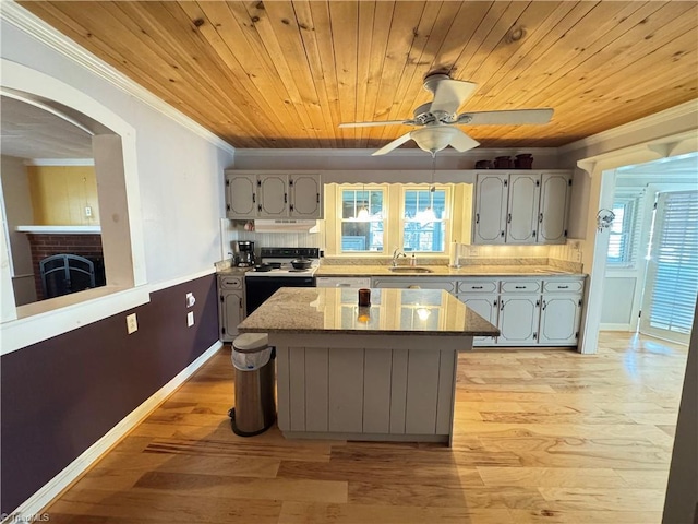 kitchen featuring ornamental molding, range with electric cooktop, gray cabinets, and a kitchen island