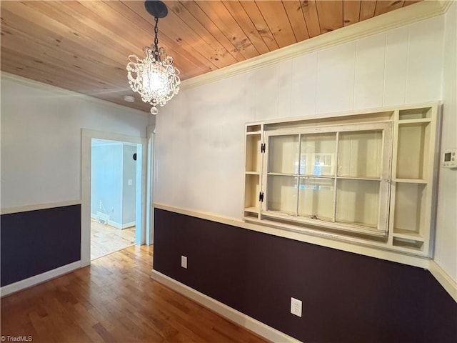 unfurnished room featuring wood-type flooring, crown molding, an inviting chandelier, and wood ceiling