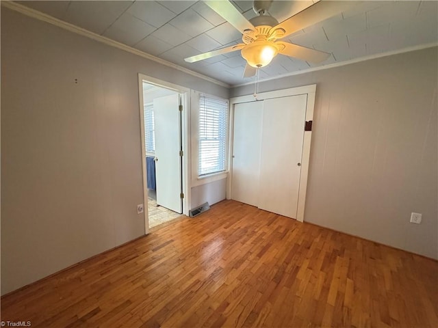 empty room with crown molding, light hardwood / wood-style floors, and ceiling fan