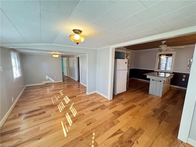 kitchen with white refrigerator, wood-type flooring, and a healthy amount of sunlight