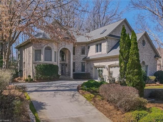 view of front of house with brick siding, driveway, and an attached garage