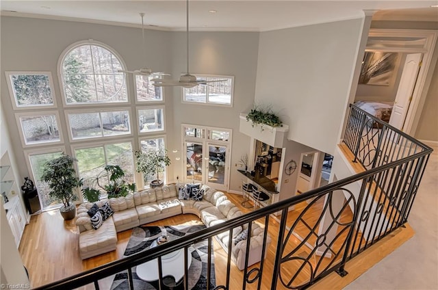 living area featuring ceiling fan, crown molding, and a towering ceiling