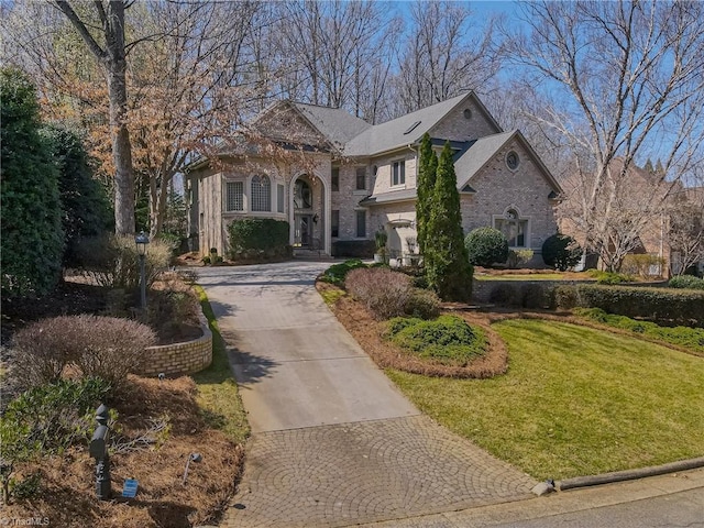 view of front of house with decorative driveway and a front yard