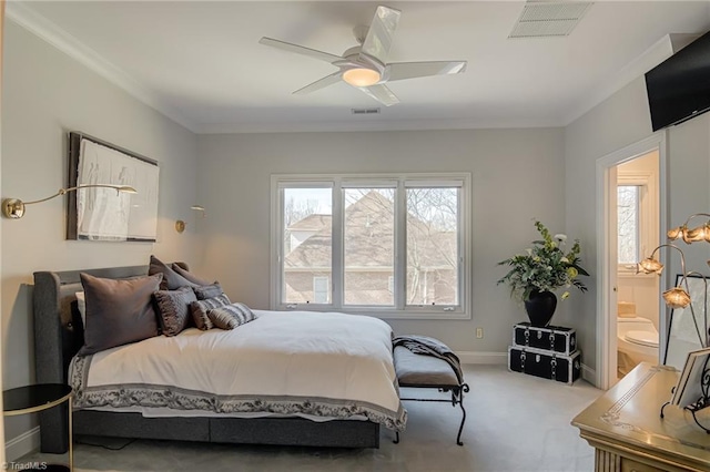 bedroom featuring baseboards, visible vents, ensuite bathroom, crown molding, and carpet flooring