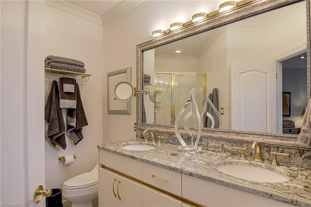 full bathroom featuring toilet, ornamental molding, a stall shower, and a sink