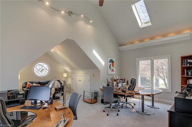 home office featuring a skylight, baseboards, and high vaulted ceiling