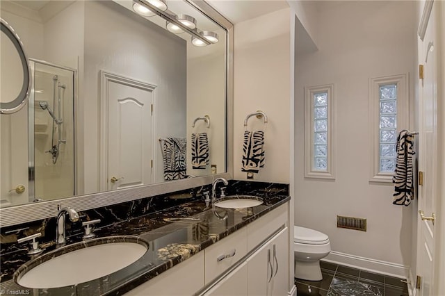 full bath featuring a sink, toilet, double vanity, and a shower stall