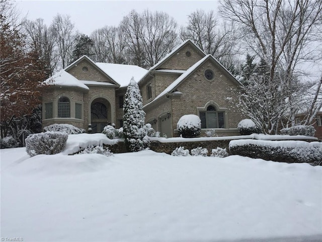 view of front of property featuring a garage and brick siding