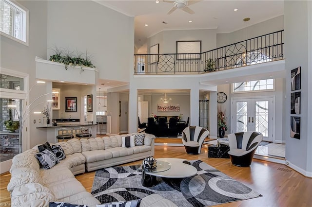 living room with baseboards, ceiling fan, ornamental molding, recessed lighting, and wood finished floors