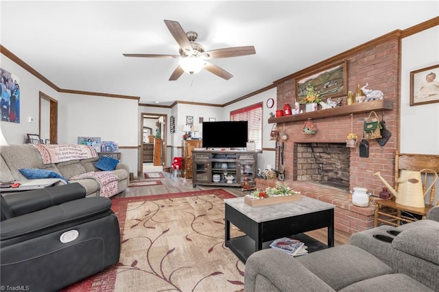 living area featuring ceiling fan, a brick fireplace, wood finished floors, and crown molding