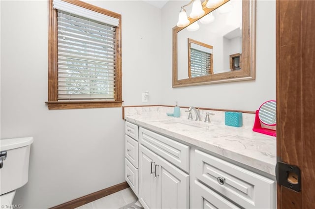 bathroom with vanity, toilet, baseboards, and tile patterned flooring