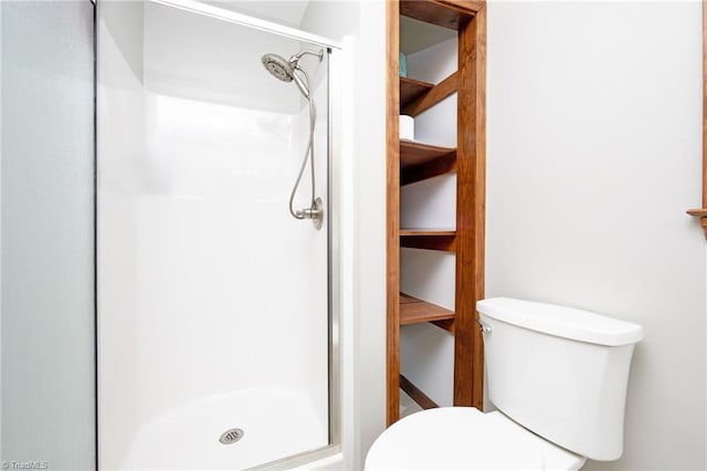 bathroom featuring a shower stall and toilet