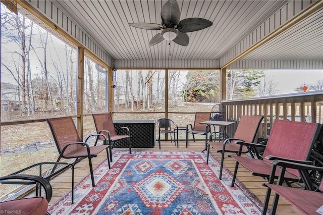 sunroom / solarium with a healthy amount of sunlight and ceiling fan