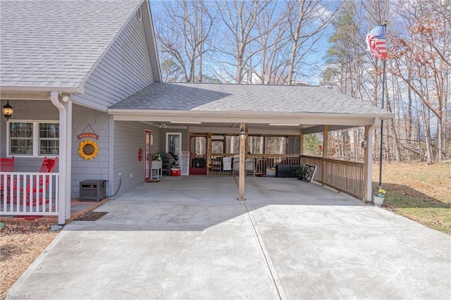 exterior space featuring an attached carport, concrete driveway, and roof with shingles