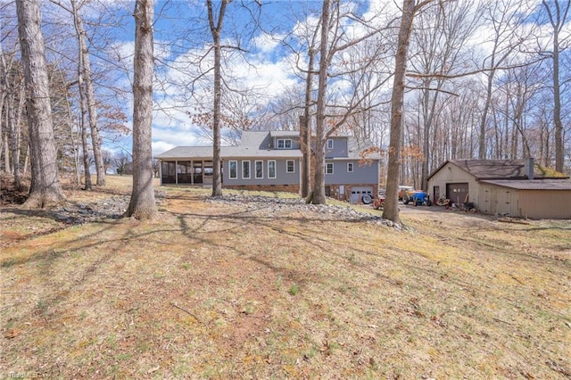 exterior space featuring a detached garage and a sunroom