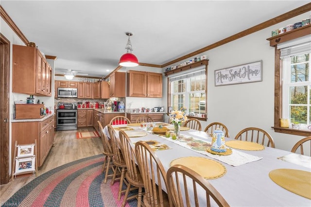 dining area with crown molding and light wood finished floors