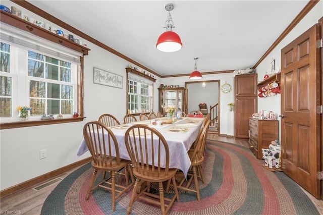 dining space with visible vents, baseboards, and crown molding