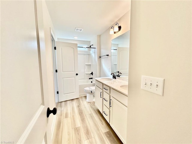 full bathroom featuring hardwood / wood-style flooring, vanity, tub / shower combination, and toilet