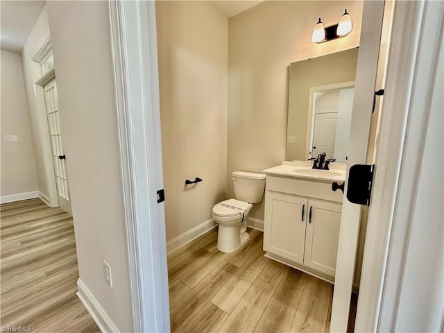 bathroom featuring vanity, hardwood / wood-style flooring, and toilet