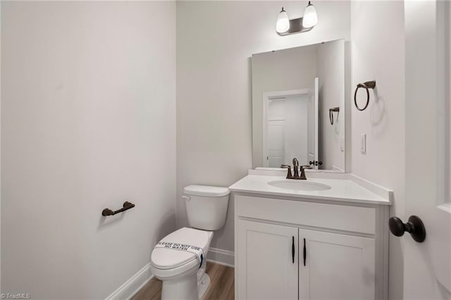 bathroom featuring hardwood / wood-style flooring, vanity, and toilet