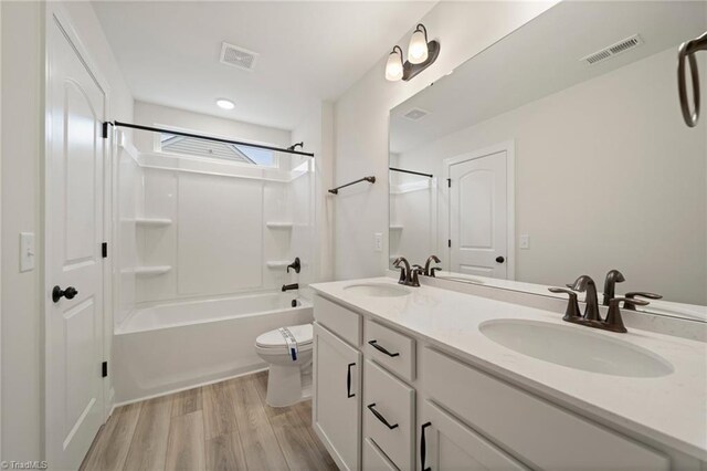 full bathroom featuring washtub / shower combination, wood-type flooring, toilet, and vanity