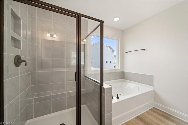 bathroom with plus walk in shower and hardwood / wood-style floors