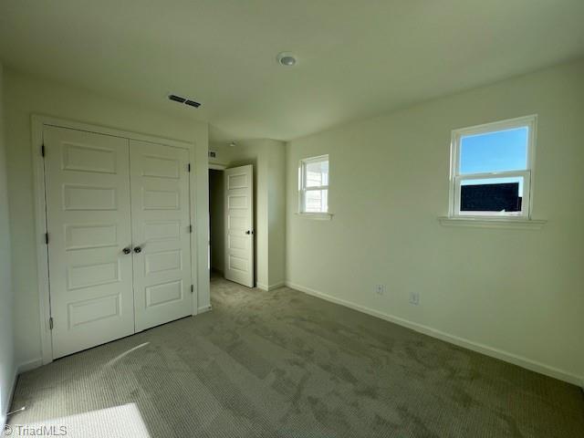 unfurnished bedroom featuring a closet and carpet flooring